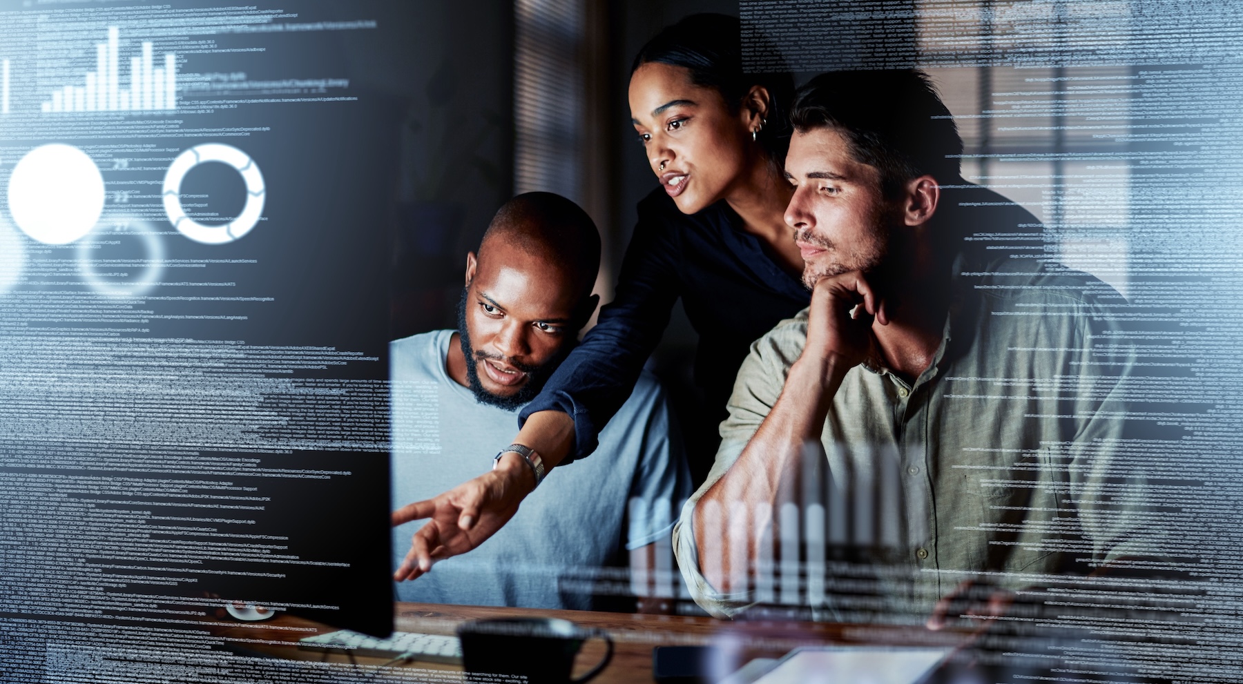 team of programmers talking in front of a screen full of code